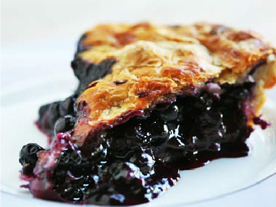 A Slice of the grilled BBQ Peach & Blueberry Pie on a white plate.