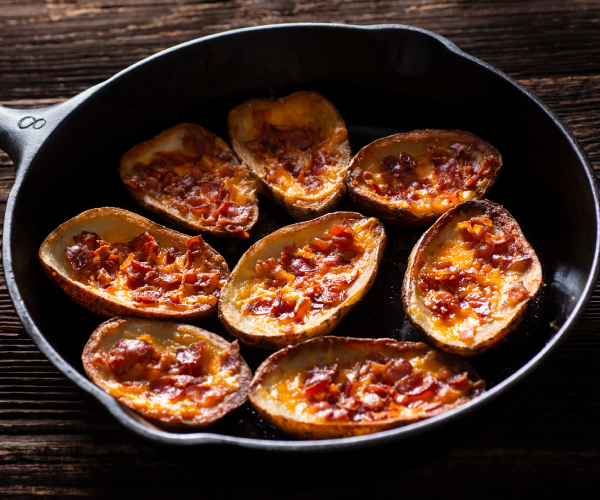 Finished potato skins in a cast iron skillet.