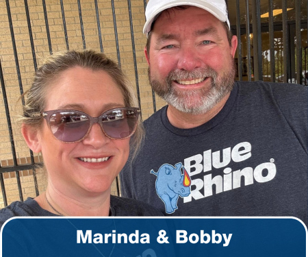Closeup head shots of a man and woman wearing Blue Rhino shirts.