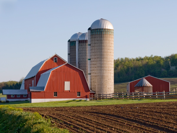 View of a farm, with red barns and silos.