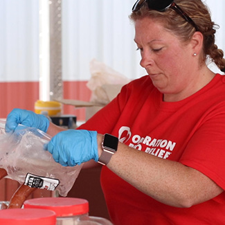 Operation BBQ Relief volunteer making meals.