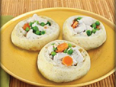 Three mini pot pies on a yellow plate, sitting on a bamboo mat.