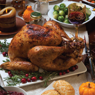 Finished grilled turn on a white plate on a table with other Thanskgiving foods.