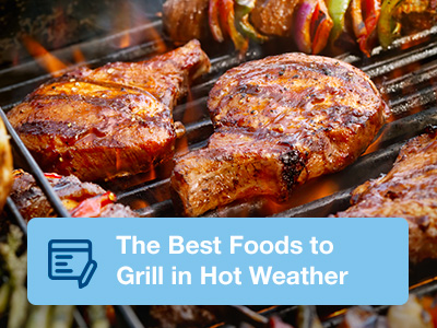 Closeup of pork chops being grilled on standup propane grill.