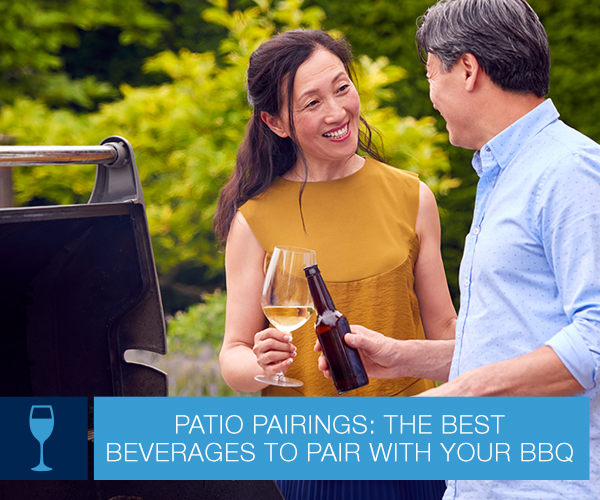 Man and woman outside standing next to a standup gas grill.