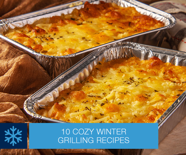 Two aluminum pans of finished Grilled Cheesy Portobello Mushrooms sitting on a table.