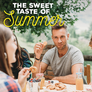 Friends sitting at a patio table, eating snacks.