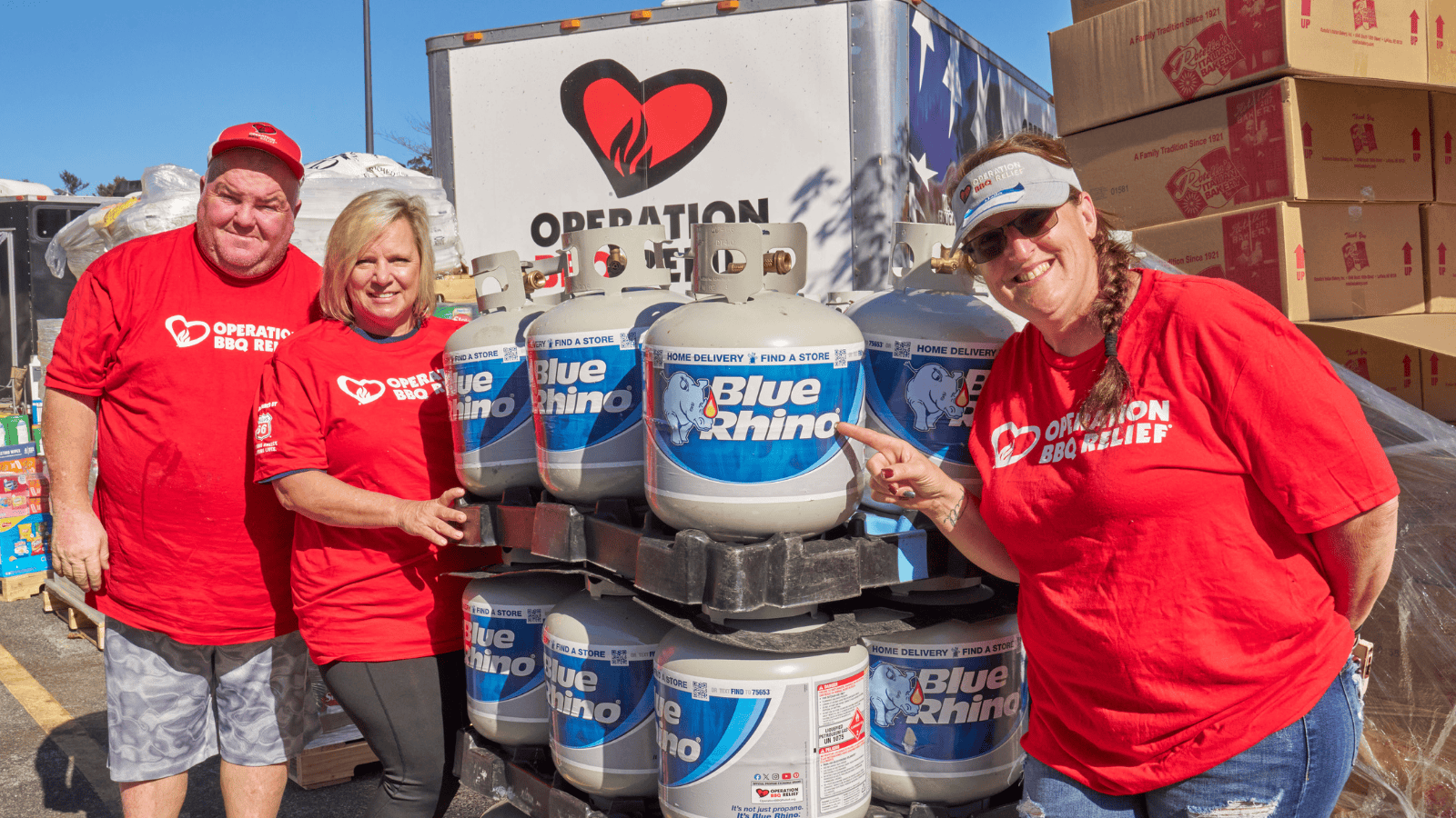 OBR volunteers standing beside a pallet of fresh Blue Rhino tanks.