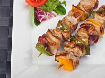 Two finished kabobs on a white plate.