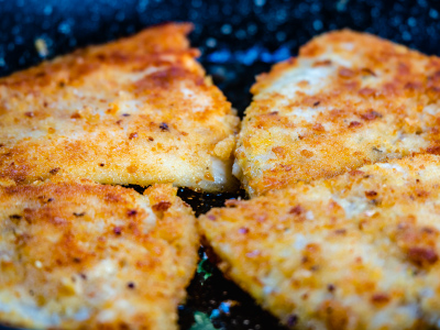 Closeup of grilled toasted pecan tilapia on a blue plate.