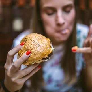 A woman eating a cheeseburger.