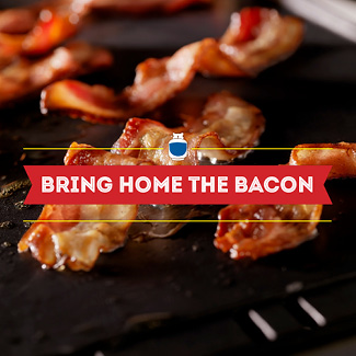 Closeup of bacon being cooked on a griddle.