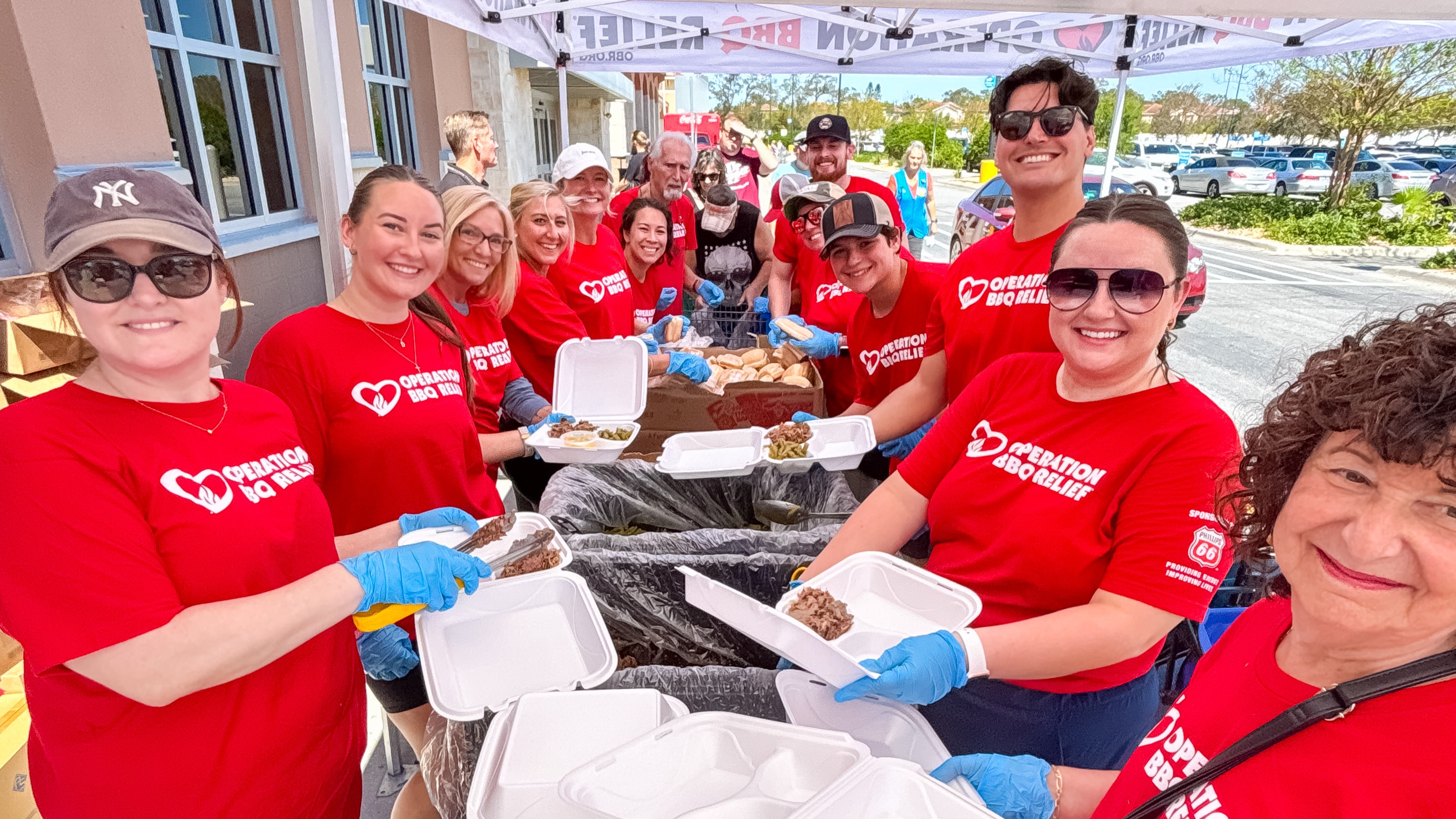 OBR volunteers standing at a table packging meals.