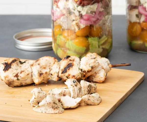 Grilled turkey kebabs on a wood cutting board.
