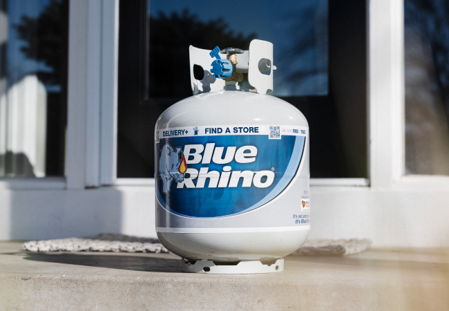 A fresh Blue Rhino tanks sitting on the front steps of a house.