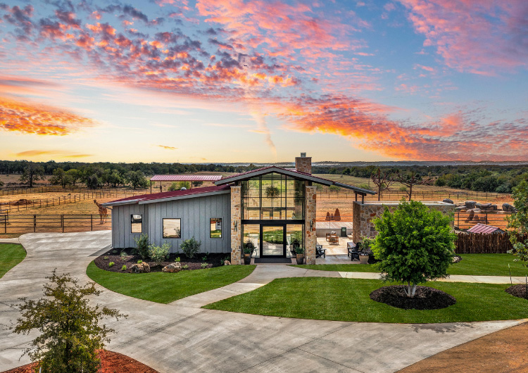 Longneck Manor's Welcome Center set against a partyly cloudy sky at sunset.