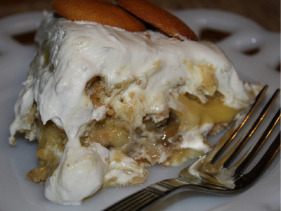 Slice of the grilled Carolina Nana Pudding on a white plate with a fork.