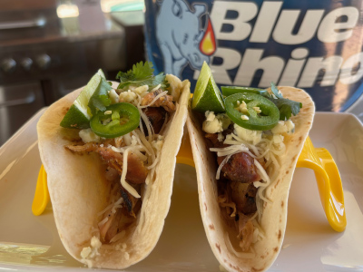 Finished buffalo chicken tacos on a white plate with a fresh Blue Rhino tank in the background.