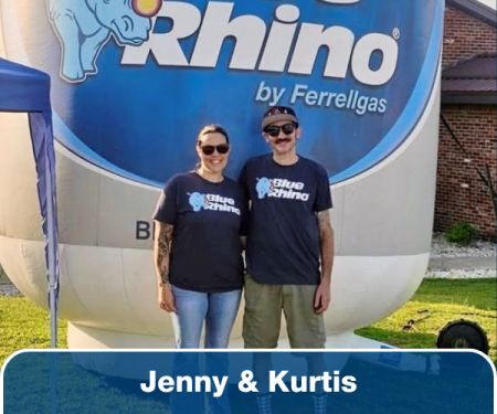 A woman and man wearing Blue Rhino shirts standing in front of an inflatable Blue Rhino tank.
