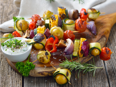 Finished skewers on a wood plank, sitting on a wood table.