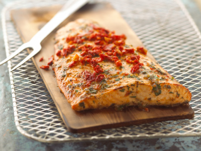 Grilled salmon filet on a cedar plank on a wire rack.