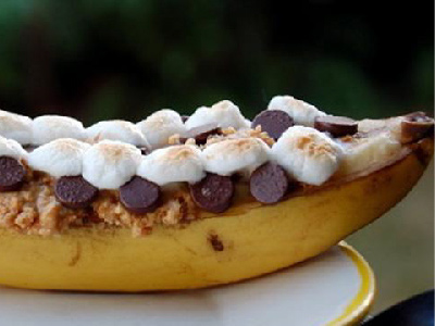 Finished campfire banana boat on a white plate.