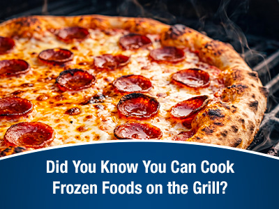 Closeup of a frozen pizza being cooked on a propane grill.